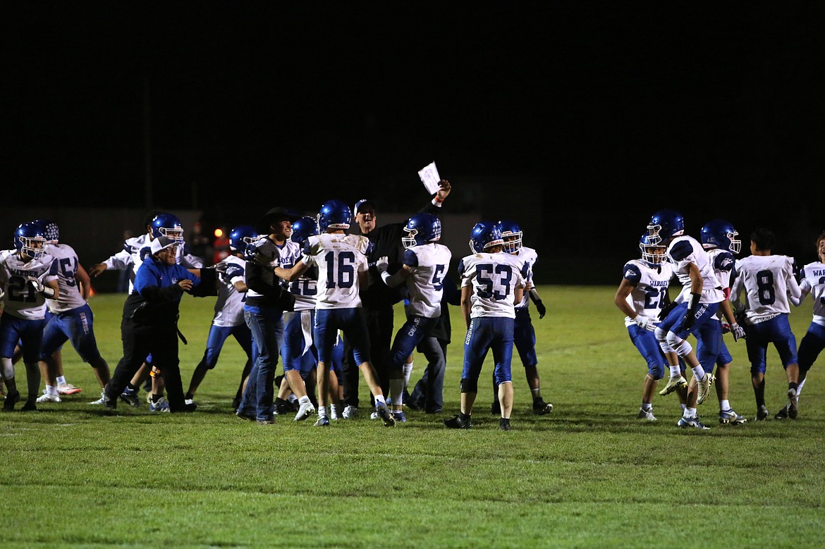 Warden players and coaches celebrate on the field after stopping the Bronco offense on fourth down in overtime.