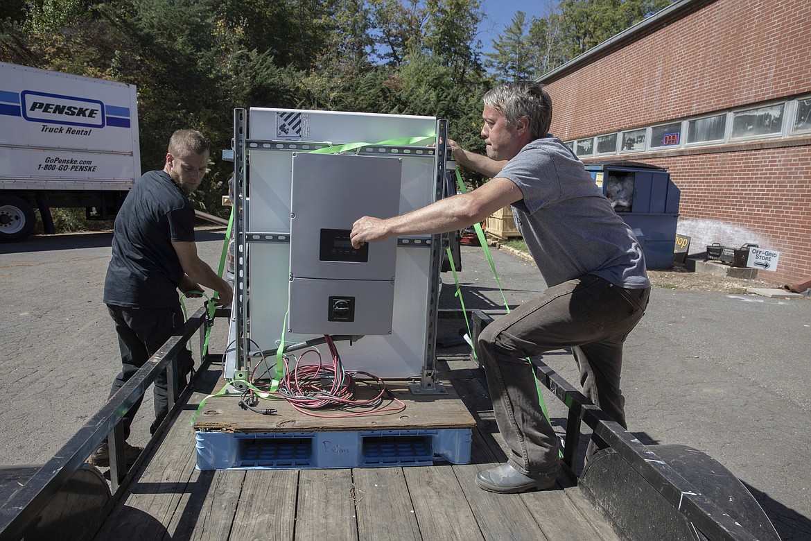 Henry Kovacs, left, and Hayden Wilson, right, volunteers with the Footprint Project, load two Tesla Powerwall batteries to deliver to communities impacted by Hurricane Helene in Mars Hill, N.C. on Oct. 9, 2024. (AP Photo/Gabriela Aoun Angueria)