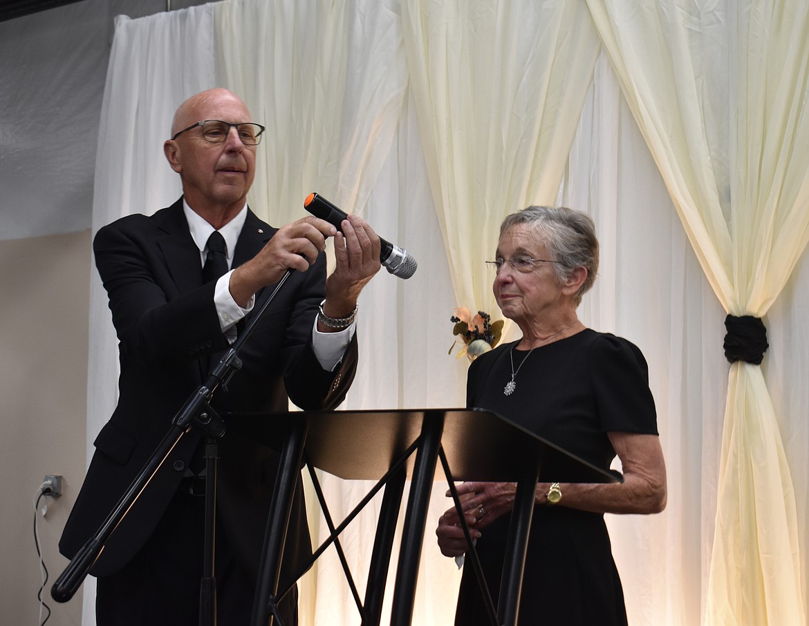 Our Lady of Fatima Catholic Church Deacon Mark Krcma adjusts the microphone for Paula Hochstatter, who accepted an award on behalf of her husband Harold at the Crossroads Resource Center banquet Saturday.