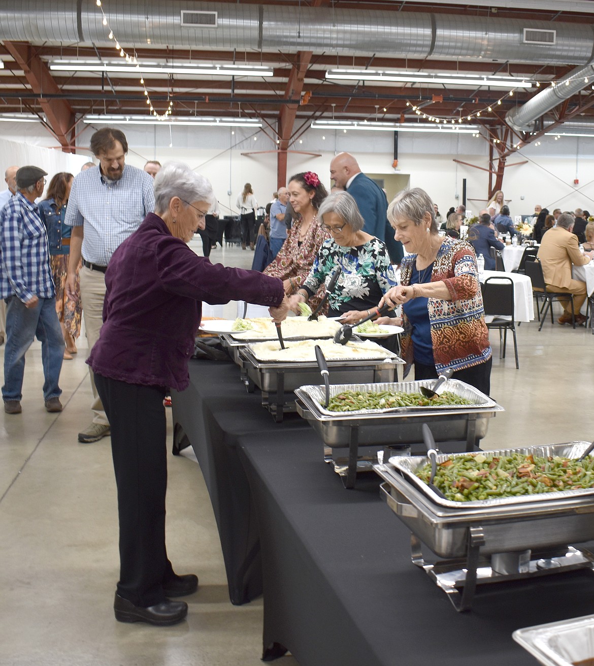 Attendees at the Crossroads Resource Center bajnquet help themselves to mashed potatoes and veggies, part of the prime rib dinner catered by Top Gun Concessions & Catering Saturday.