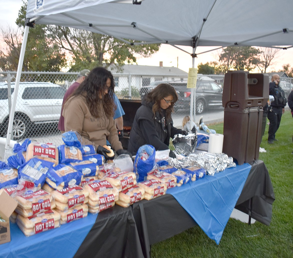 Sonia Garcia, left, and Mary Alvarado lay out hot dogs at the Moses Lake Police Department’s Faith & Blue event Friday.