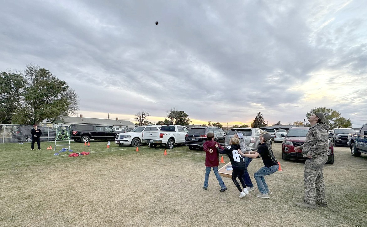 Players lob a football high in the air on one of the games set up at Faith & Blue Friday at Lions Field in Moses Lake.