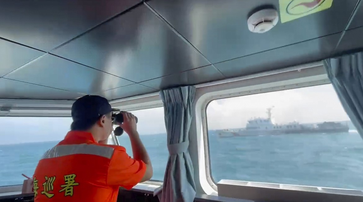 In this screen grab from video released by the Taiwan Coast Guard, a member of the Taiwan Coast Guard monitors a China Coast Guard boat as it passes near the coast of Matsu islands, Taiwan on Monday, Oct. 14, 2024. (Taiwan Coast Guard via AP)