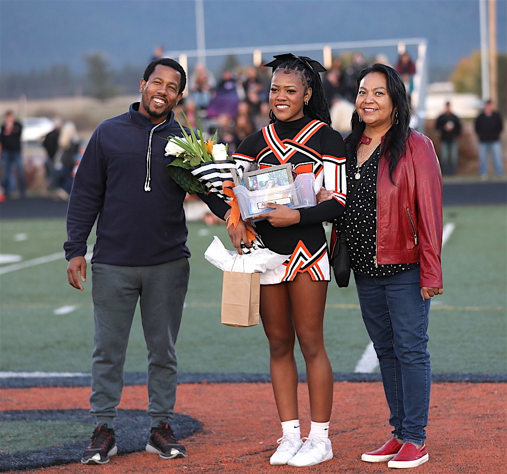 Maiden Ailiyah Stewart walks with her parents on Senior Night in Ronan. (Susan Lake photo)