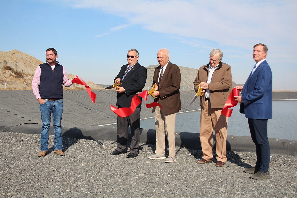 Port of Moses Lake Facilities Director Milton Miller, left and port Executive Director Dan Roach, right, hold the ribbon as commissioners Darrin Jackson, second from left, Kent Jones, third from left, and Stroud Kunkle, second from right, cut it to commemorate upgrades to the port’s water reuse system.