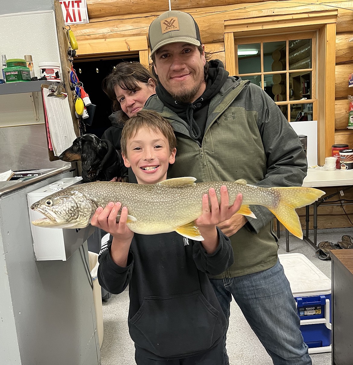 Lindsay Carter, backed by Shaunda Albert of Ronan and Britton Salois of Pablo, shows off one of their handsome Mack Days lake trout entries. (CSKT Fisheries)