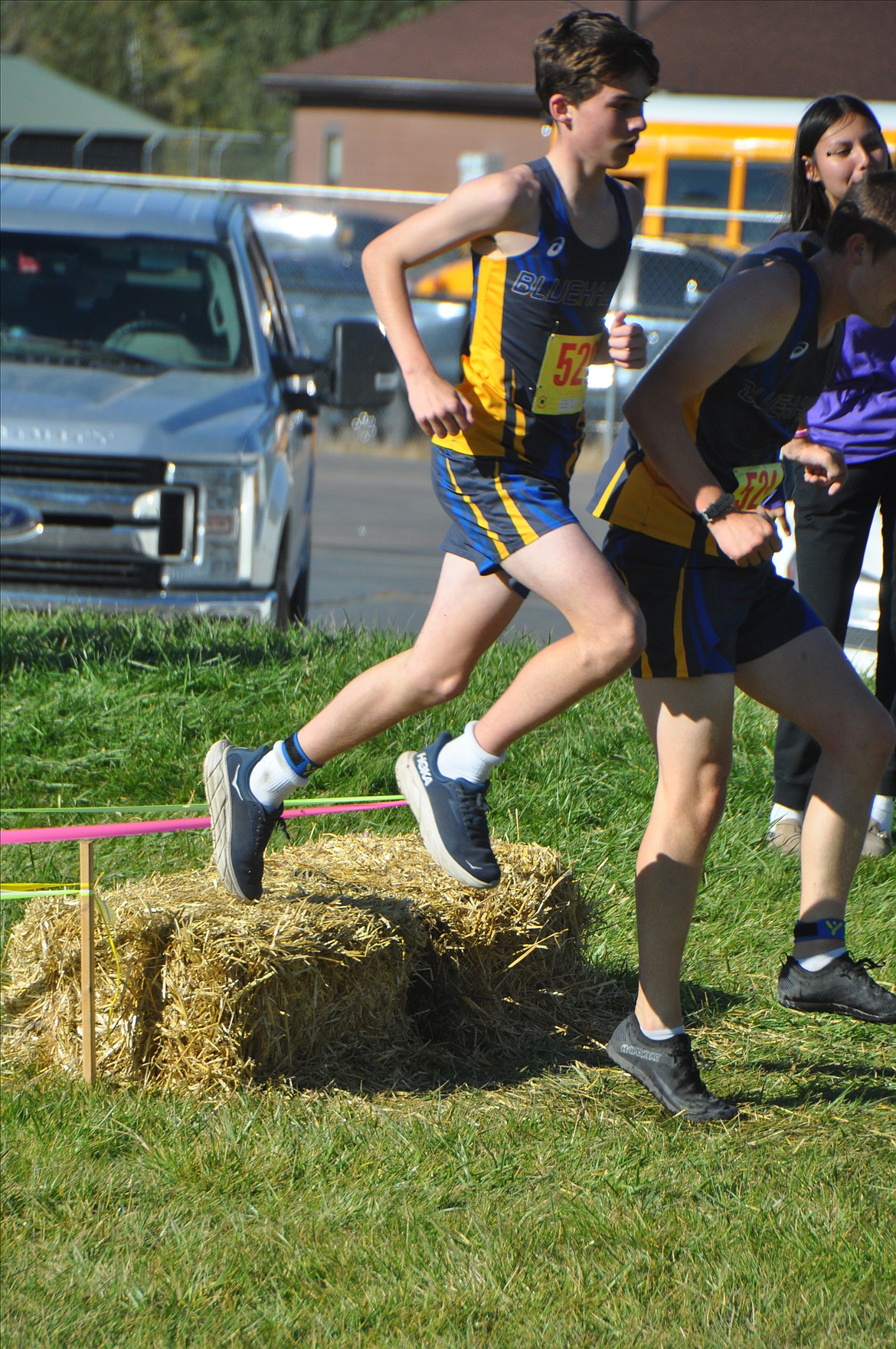 Thompson Falls eighth grader Nathan Baxter jumps over a hay bale on the Silver Fox Golf Club course during this past weekend's Mission Shadows Invitational cross-country event. (Photo by Sarah Naegeli)