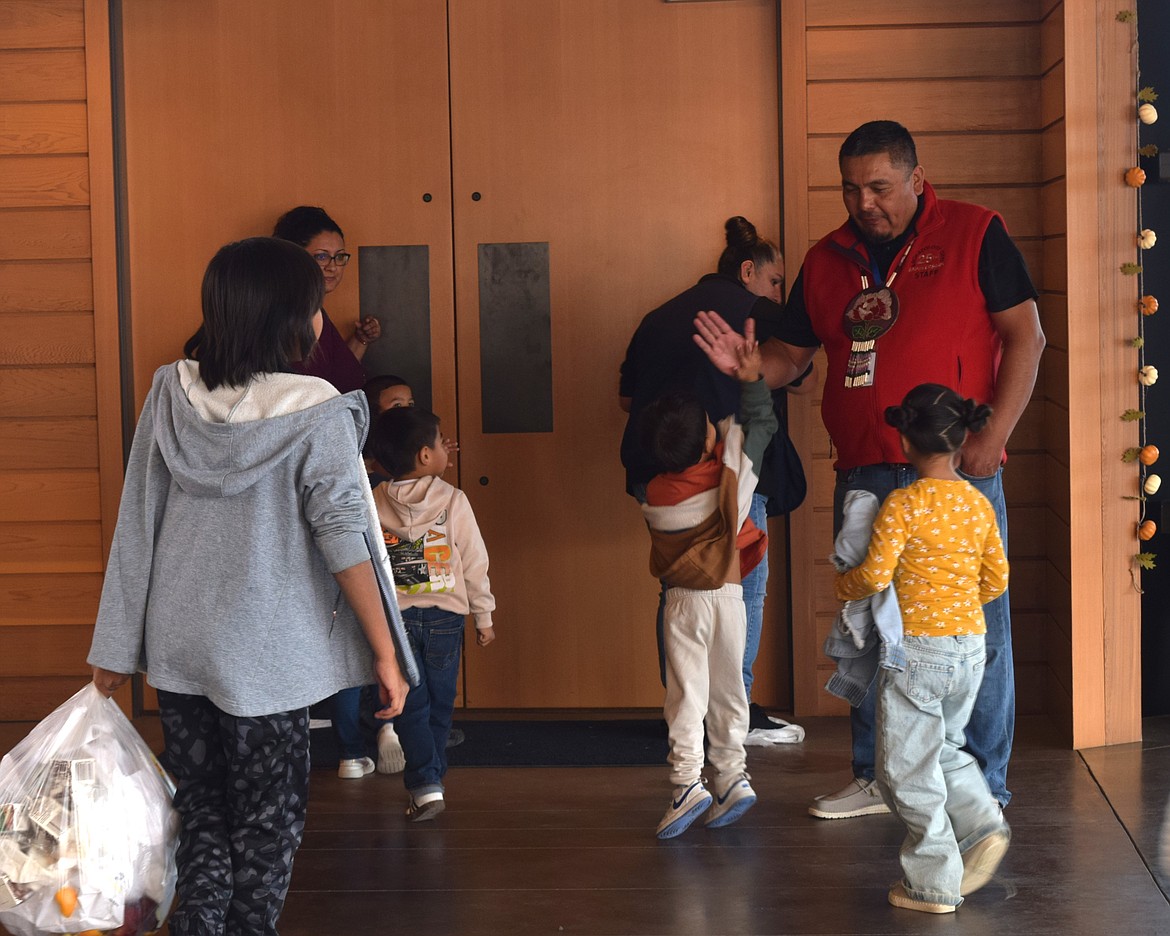 An employee at the Wanapum Heritage Center high-fives a student goodbye after he spent the morning at the Archeology Day event.