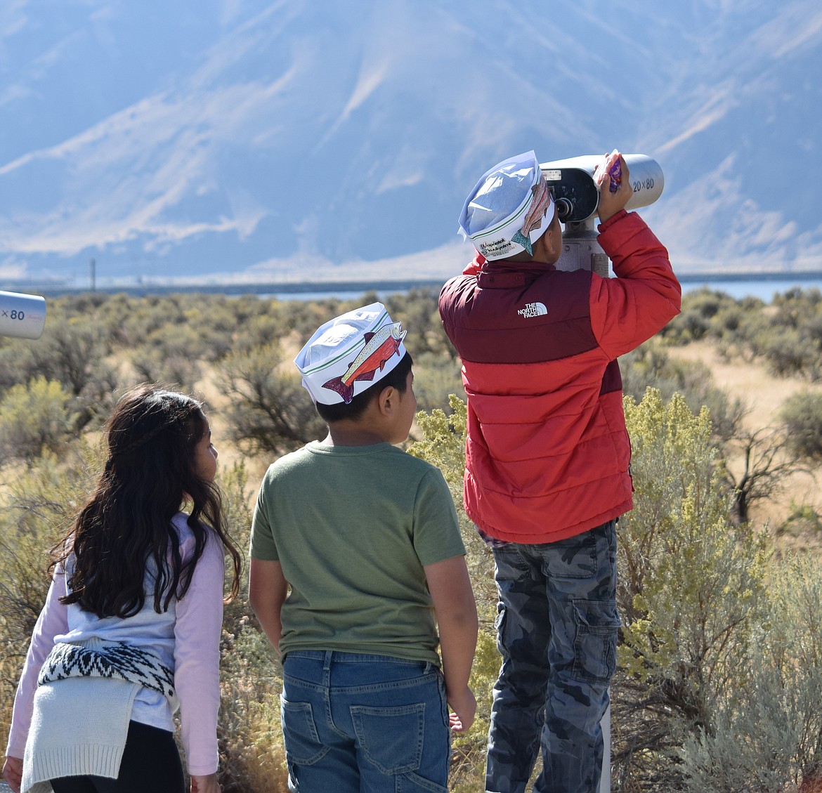 Two students wait as a student looks through a viewfinder at the Wanapum Heritage Center.