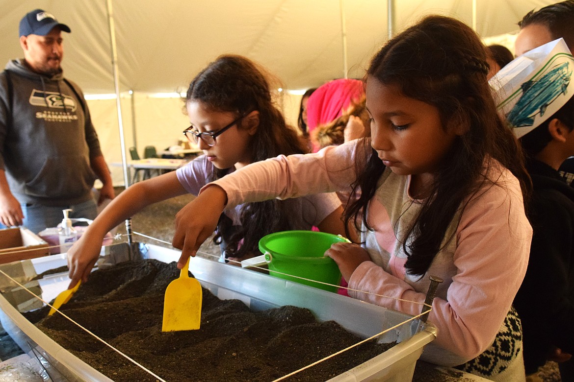 Two students dig to find bones and artifacts on the first day of the Archeology Days hosted at the Wanapum Heritage Center.