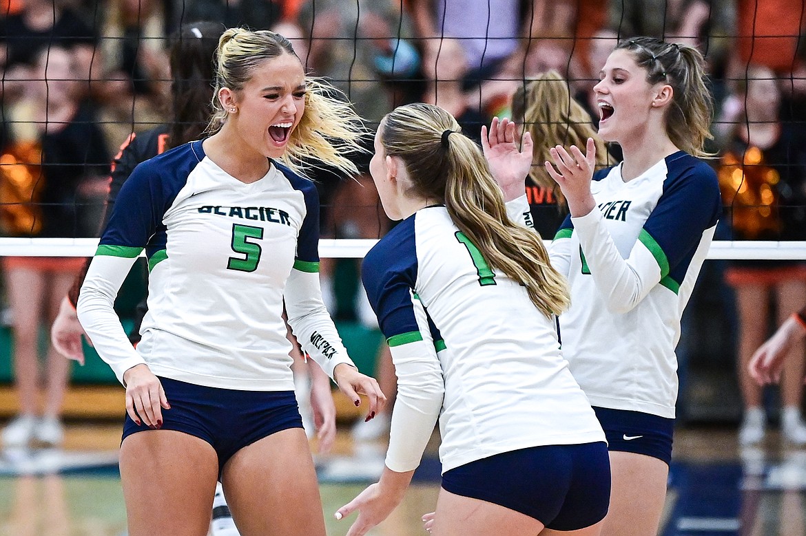 Glacier's Mali Carrol (5), Stella Bayard (14) and Jaidyn Pevey (6) celebrate after a point against Flathead at Glacier High School on Tuesday, Oct. 15. (Casey Kreider/Daily Inter Lake)