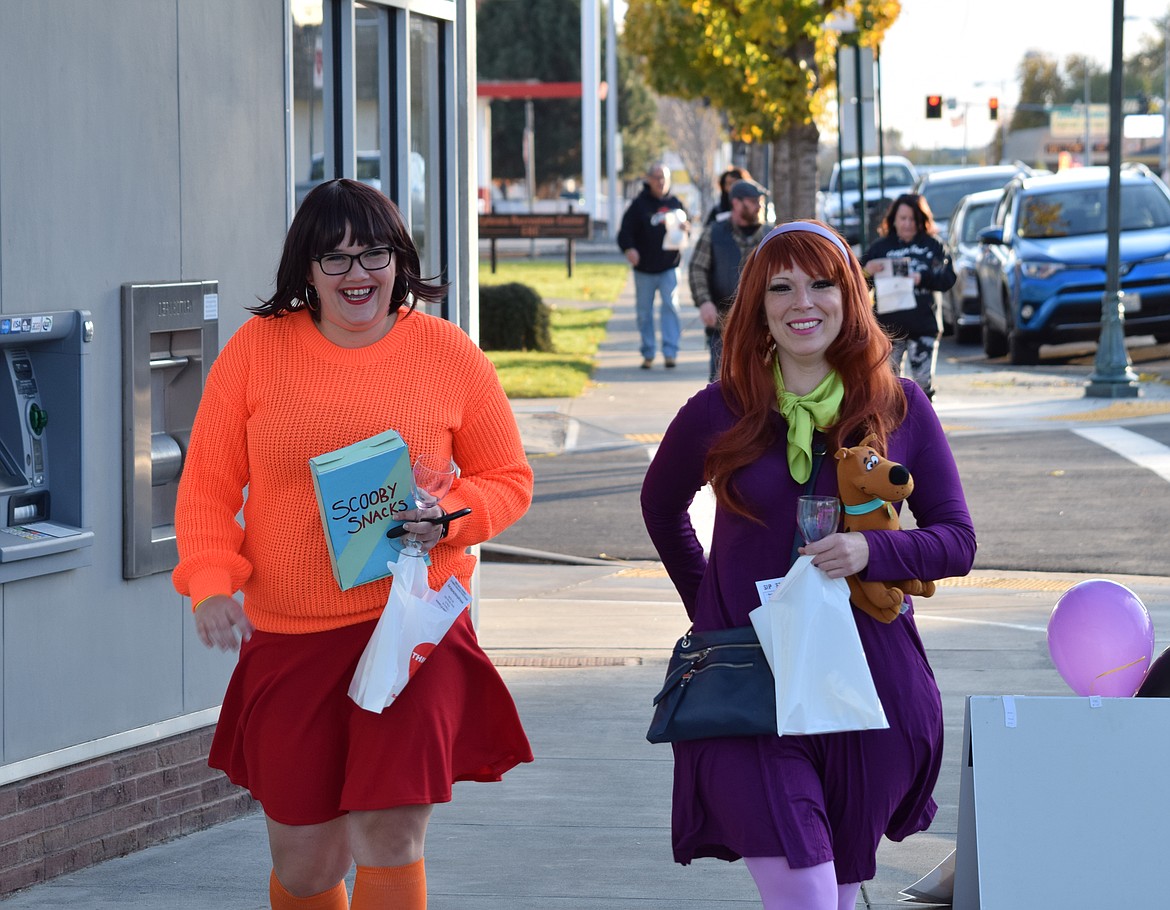 Armed with Scooby Snacks, Velma and Daphne, known the rest of the year as Jasmine Rice, left, and Lisa Pearl, walk down Basin Street in Ephrata at a previous Wine Walk. This year’s walk is Saturday.