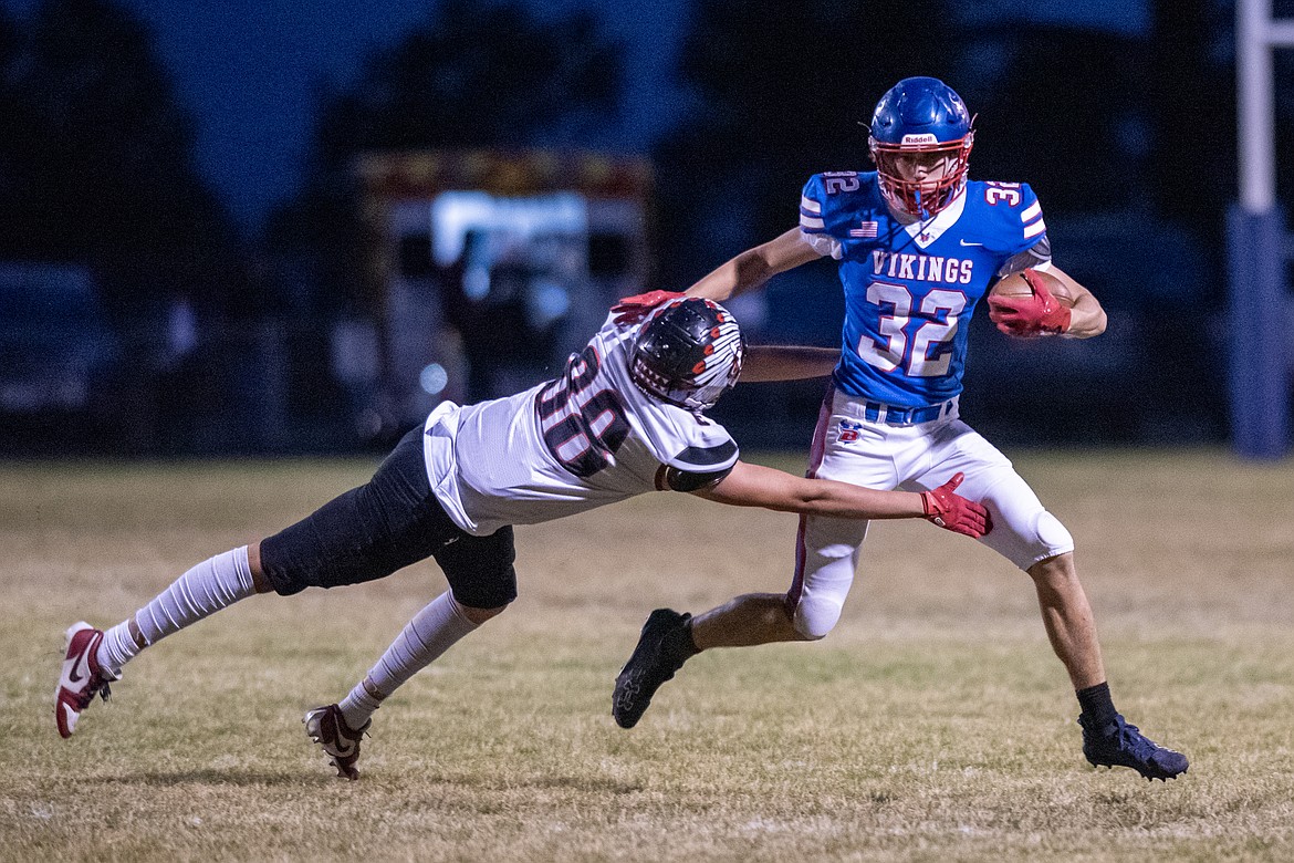 Austin Savik dodges a Browning Indian in the Homecoming football game Friday, Oct. 11. (Avery Howe/Bigfork Eagle)