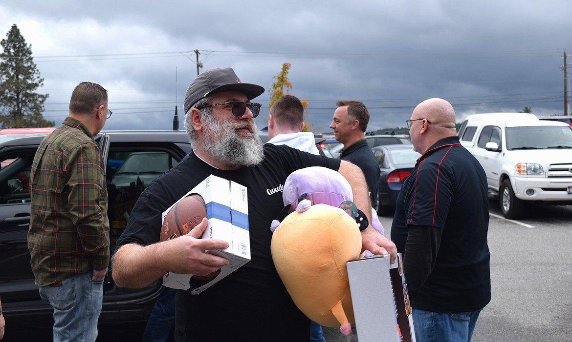 Cascadia Pizza Co. owner Raffi Peltekian carries toys inside to be donated during Wednesday's Toys for Tots event.