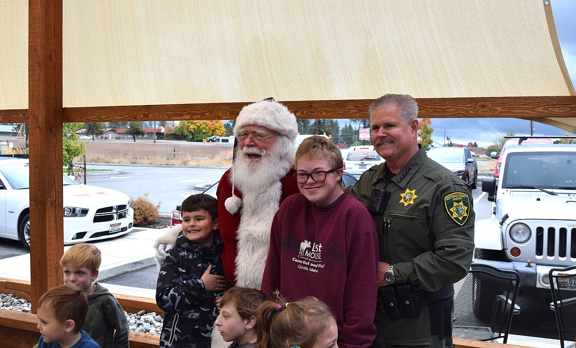 Children are all smiles as they pose with Santa Claus and Kootenai County Sheriff Bob Norris at Cascadia Pizza Co. on Wednesday.