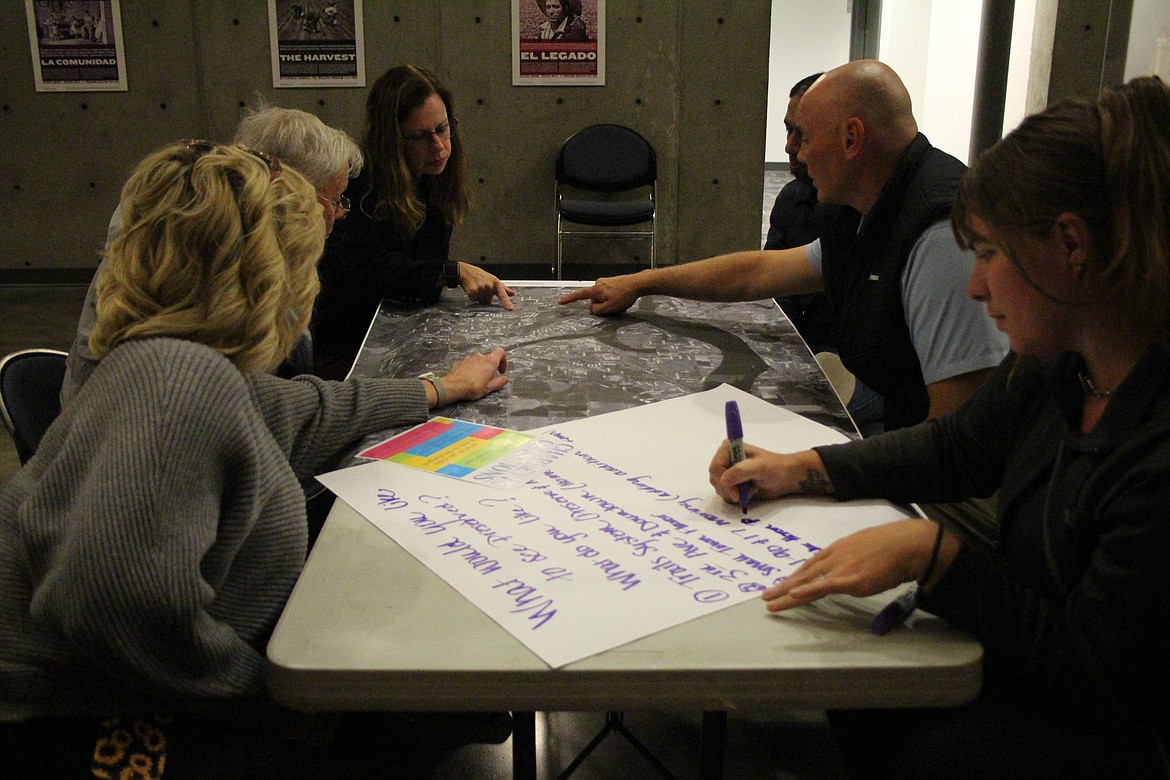 Participants check a map of Moses Lake while discussing the present and future of traffic and development in and around the city during a Monday meeting.