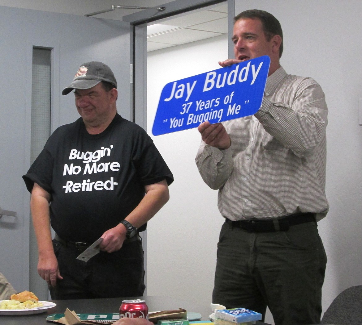 Todd Feusier, director of Coeur d'Alene's Streets and Engineering Department, presents a parting gift to Jay Leake at his retirement party.