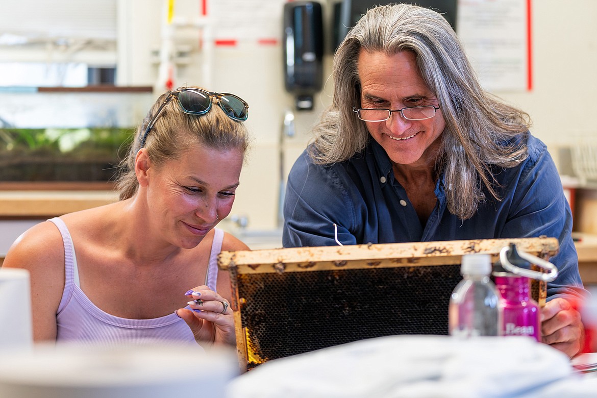 Beekeeping instructor Scott Debnam instructs student Joelle DeHaven during UM’s in-person beekeeping field days. (UM Photos by Coral Scoles-Coburn)