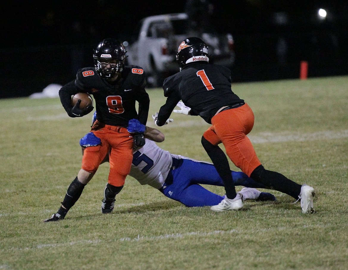 MARK NELKE/Press
Trenton McLean (8) of Post Falls tries to escape the tackle of Jayson Cady (5) of Coeur d'Alene, as Caleb Jimmerson (1) of Post Falls looks to help Friday night at Trojan Stadium.