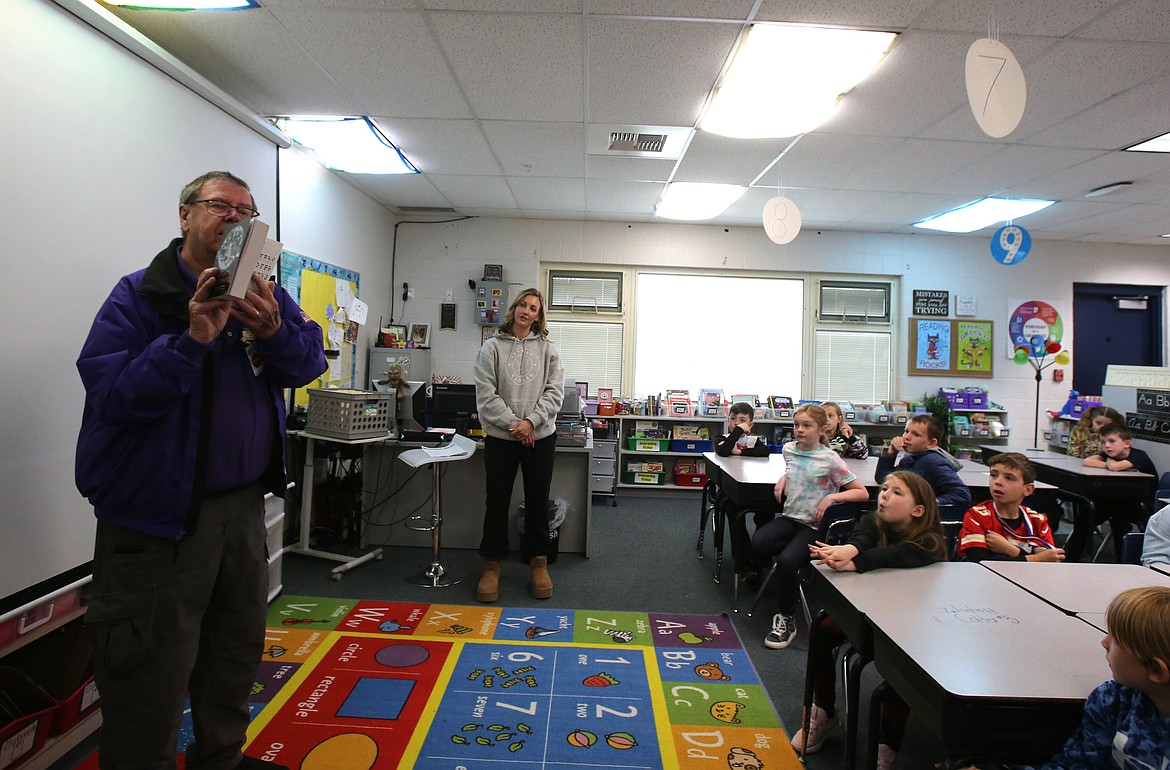 Elks member Pat Braden, left, highlights some of the cool information in "A Student's Dictionary," 750 copies of which he and fellow Elks donated to Coeur d'Alene School District third grade classrooms Friday morning.