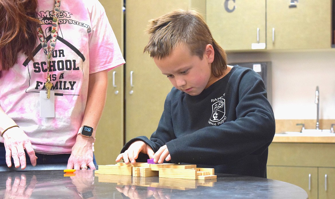 Porter, 9, builds with KAPLA planks during Thursday night's STEM Night at Ramsey Magnet School of Science.