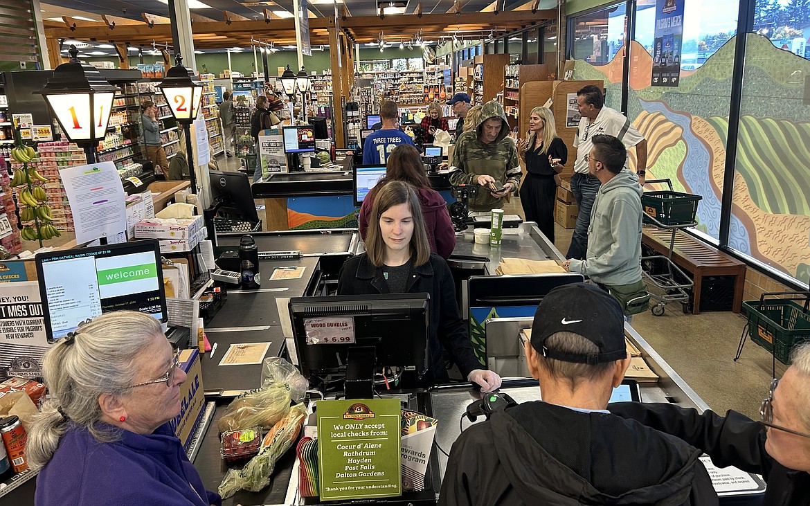 The front registers are busy on Thursday as customers mingle with checkers at Pilgrim's Market.