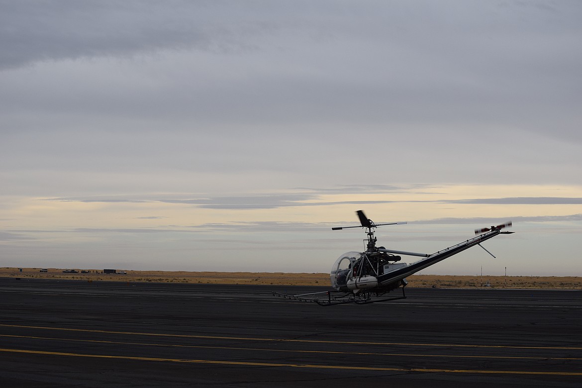 A helicopter equipped with sprayers takes off at the Ephrata airport earlier this month during a recertification fly-in for crop dusters. Like that day, temperatures are expected to be a bit cool this week with highs below 60 degrees most of the week.