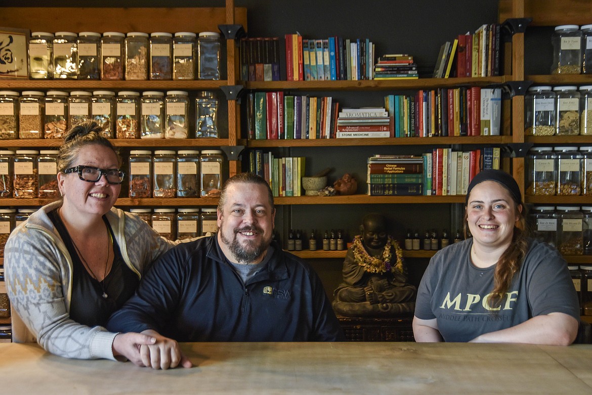 From left to right, Sara Schmidt, James Berry and Devynne Berry, co-owners of Middle Path Crossfit and Jing Shen Healing Arts, sit in their Kalispell storefront. (Kate Heston/Daily Inter Lake)