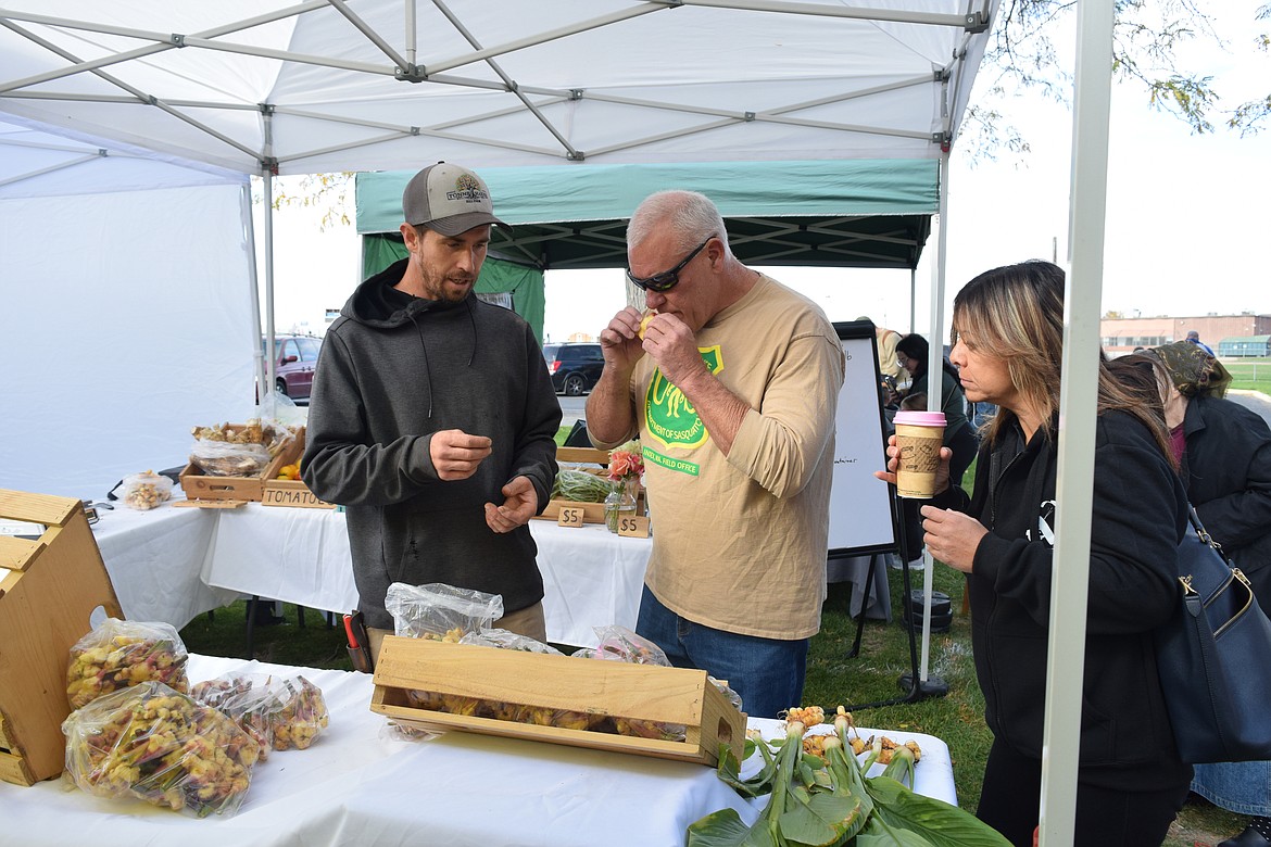 Isaac Lnenicka, from Liberty Farms based in Soap Lake broke open ginger for a customer to smell at the Moses Lake Farmers Market Oct. 19.