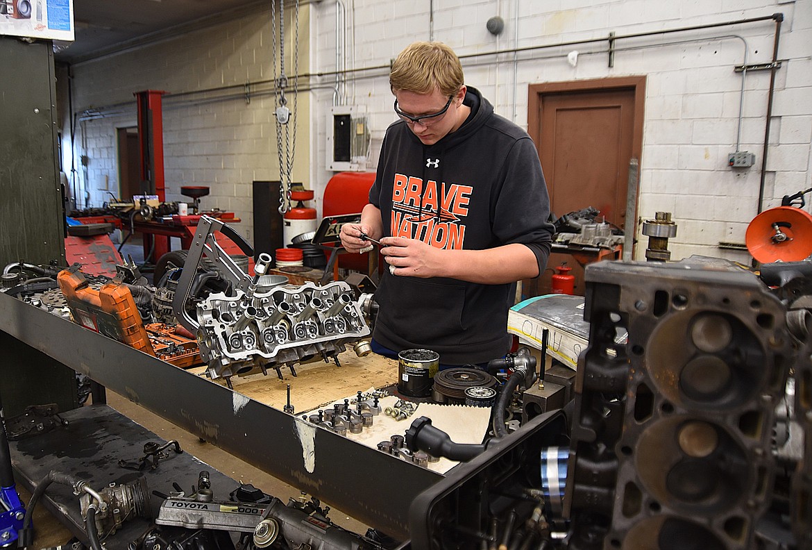 Flathead High School Automotive 4 student, junior Brady Fried, works on putting exhaust and intake valves back into cylinder heads on Wednesday, Oct. 9, 2024. The parts are from a 1989 Toyota. (Hilary Matheson/Daily Inter Lake)