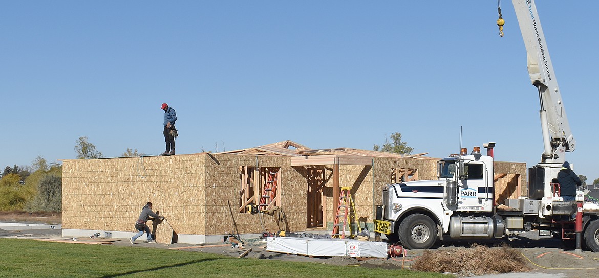 A crew puts up a home at The Refuge at Mae Valley Wednesday. Pro Made Homes, which is developing the neighborhood, can put up a home in about 60 days, according to Realtor Amy Leicht.