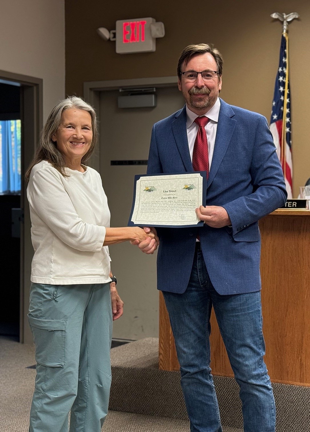 Lisa Troxel accepts an "Extra Mile Hero" award from Hayden Mayor Alan Davis.