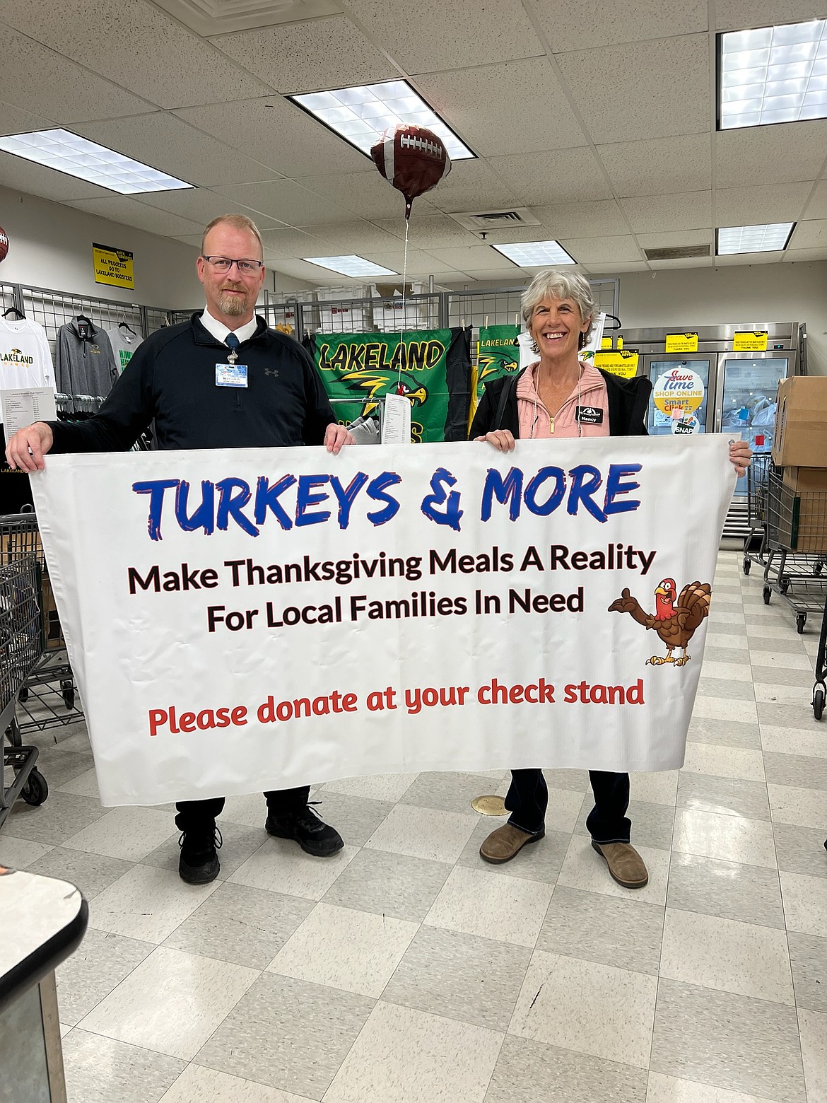 Brian Howell, manager of the Rathdrum Super One Foods is holding a banner with Turkeys and More president Nancy Nelson. All Super One stores will accept donations at the check stands to help the nonprofit group raise enough money to distribute turkeys the week before Thanksgiving. Checks may also be sent to Turkeys & More at P.O. Box 267, CDA, ID 83816, or go to turkeysandmore.org to donate safely online. For more information, call 208-765-5535.