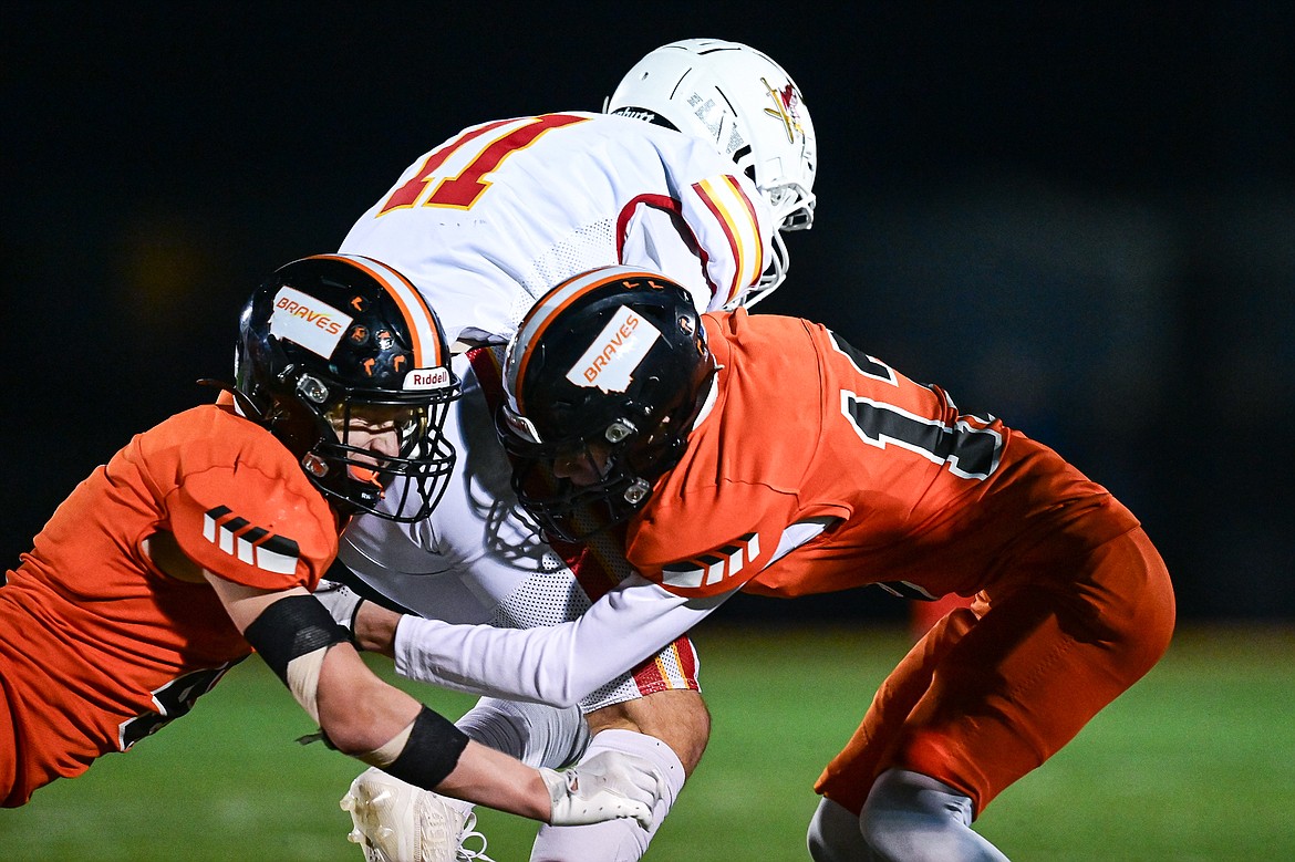 Flathead defensive backs Brett Pesola (4) and Cameron Wells (13) tackle Missoula Hellgate  wide receiver Jacob Finch (11) in the third quarter at Legends Stadium on Friday, Oct. 25. (Casey Kreider/Daily Inter Lake)