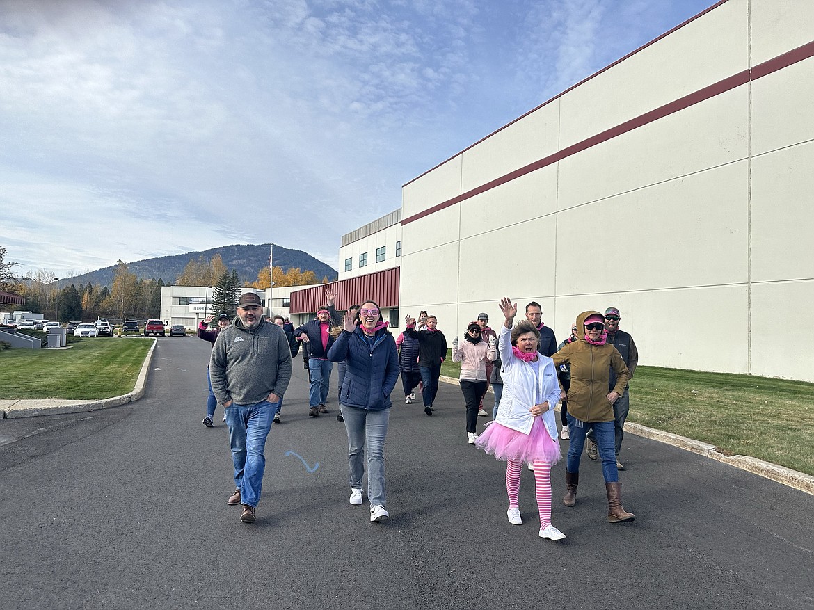 Litehouse employees smile and wave as they take part in the company's breast cancer awareness walk on Friday.