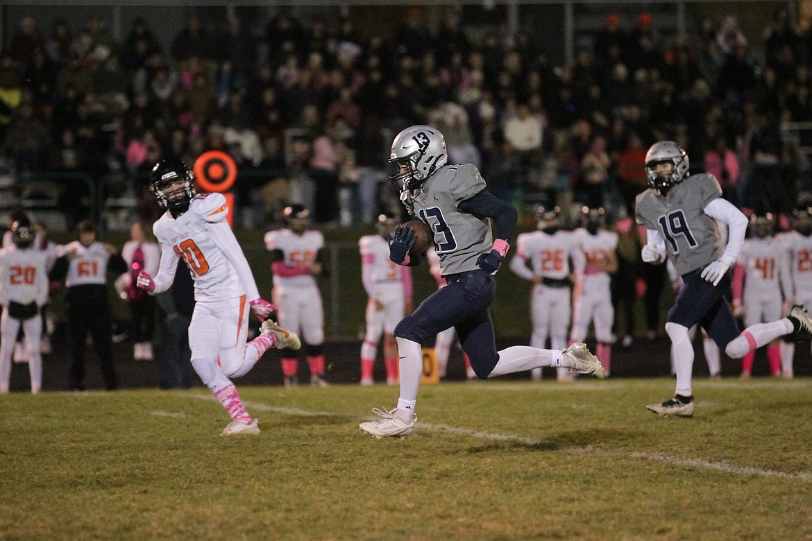 MARK NELKE/Press
Lake City sophomore Caden Tony (13) streaks down the middle of the field on a 56-yard touchdown reception in the first quarter Friday night at Lake City, as Shawn Hudson (10) of Post Falls pursues and Preston Beamesderfer (19) of Lake City trails the play.