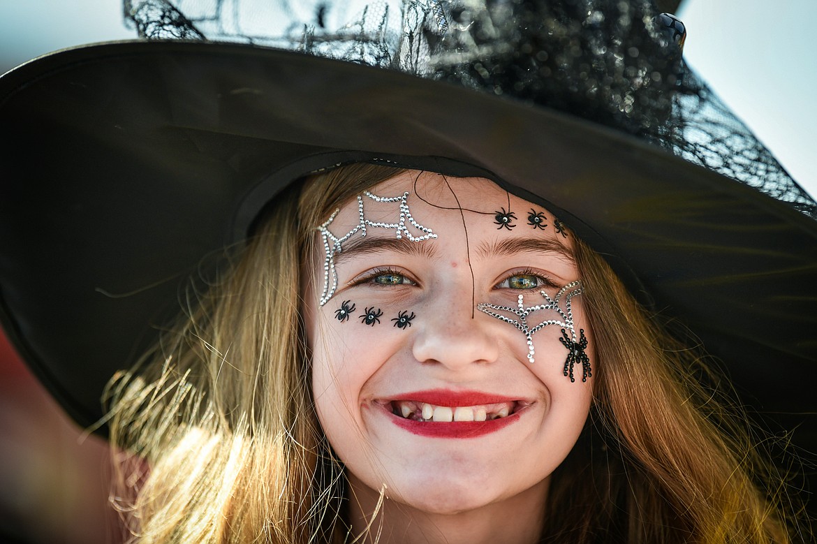 A young girl in a witch costume shows off her face decorations at the Evergreen Trunk-or-Treat at the Kalispell Moose Lodge on Saturday, Oct. 26. (Casey Kreider/Daily Inter Lake)