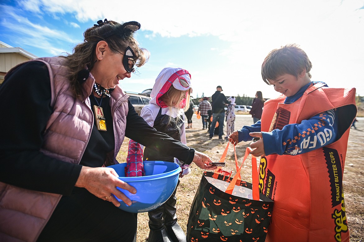 Costumed trunk-or-treaters grab candy from Don Weakly's Northwest Basic Life Support stand at the Evergreen Trunk-or-Treat at the Kalispell Moose Lodge on Saturday, Oct. 26. (Casey Kreider/Daily Inter Lake)