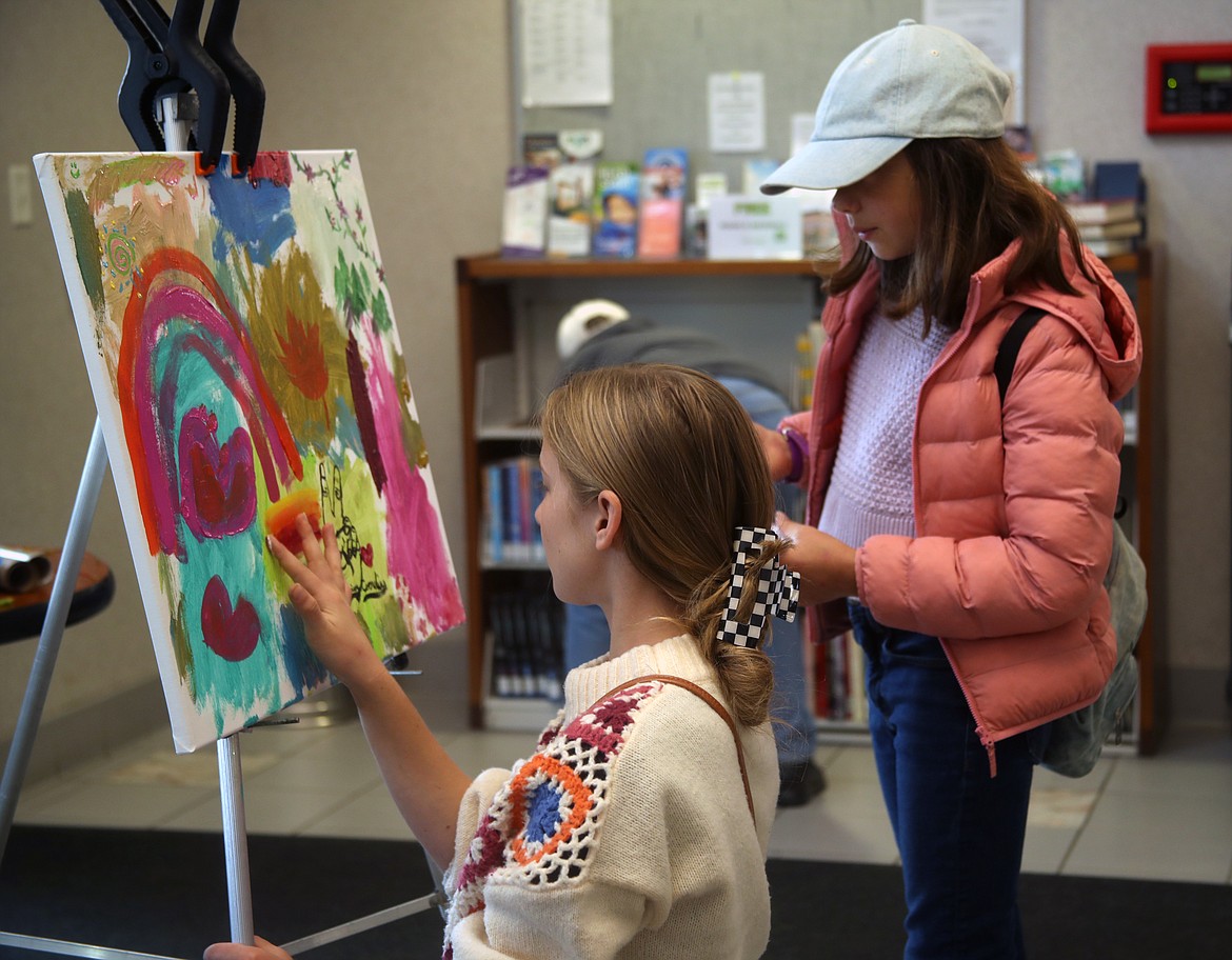 Avaiya Cornelius, foreground, works on a community painting at Saturday's Natural Connections program on arts, crafts and creating.