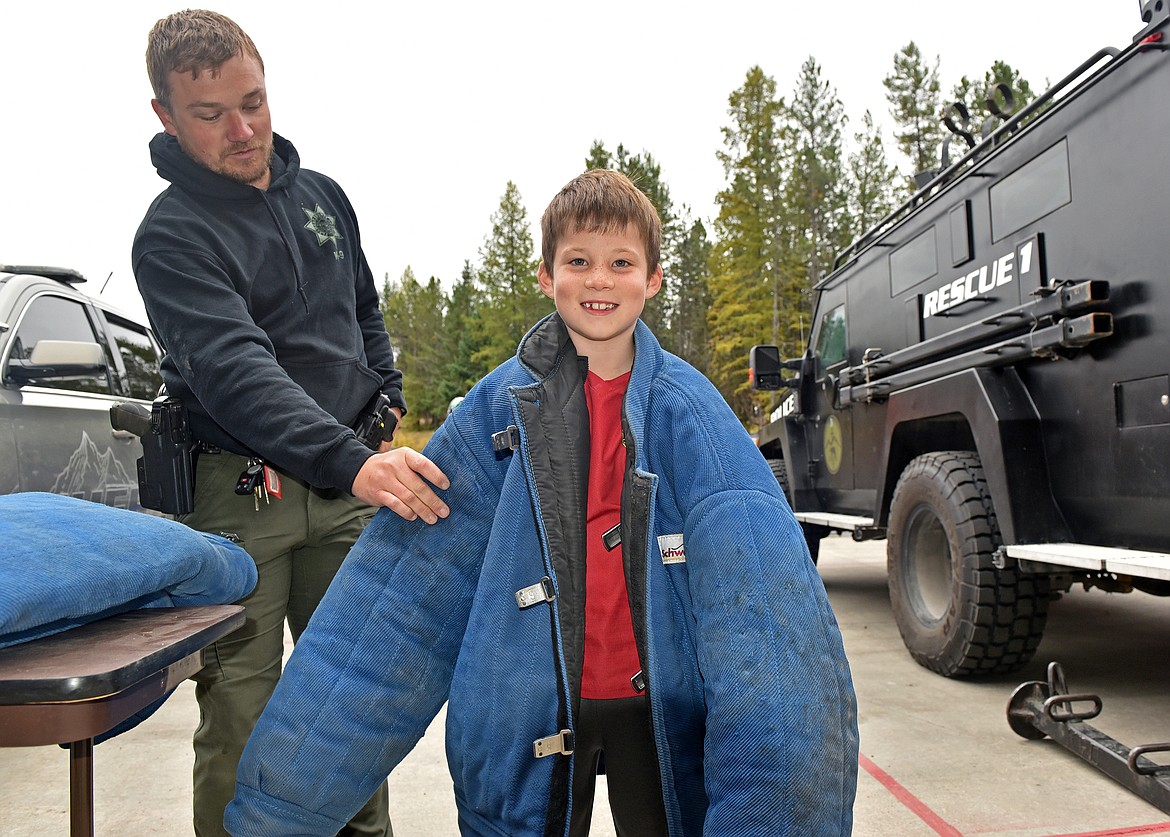 Hugh Parsons getting equipped to fight fires at the Whitefish Fire Department open house on Oct. 19. (Kelsey Evans/Whitefish Pilot)