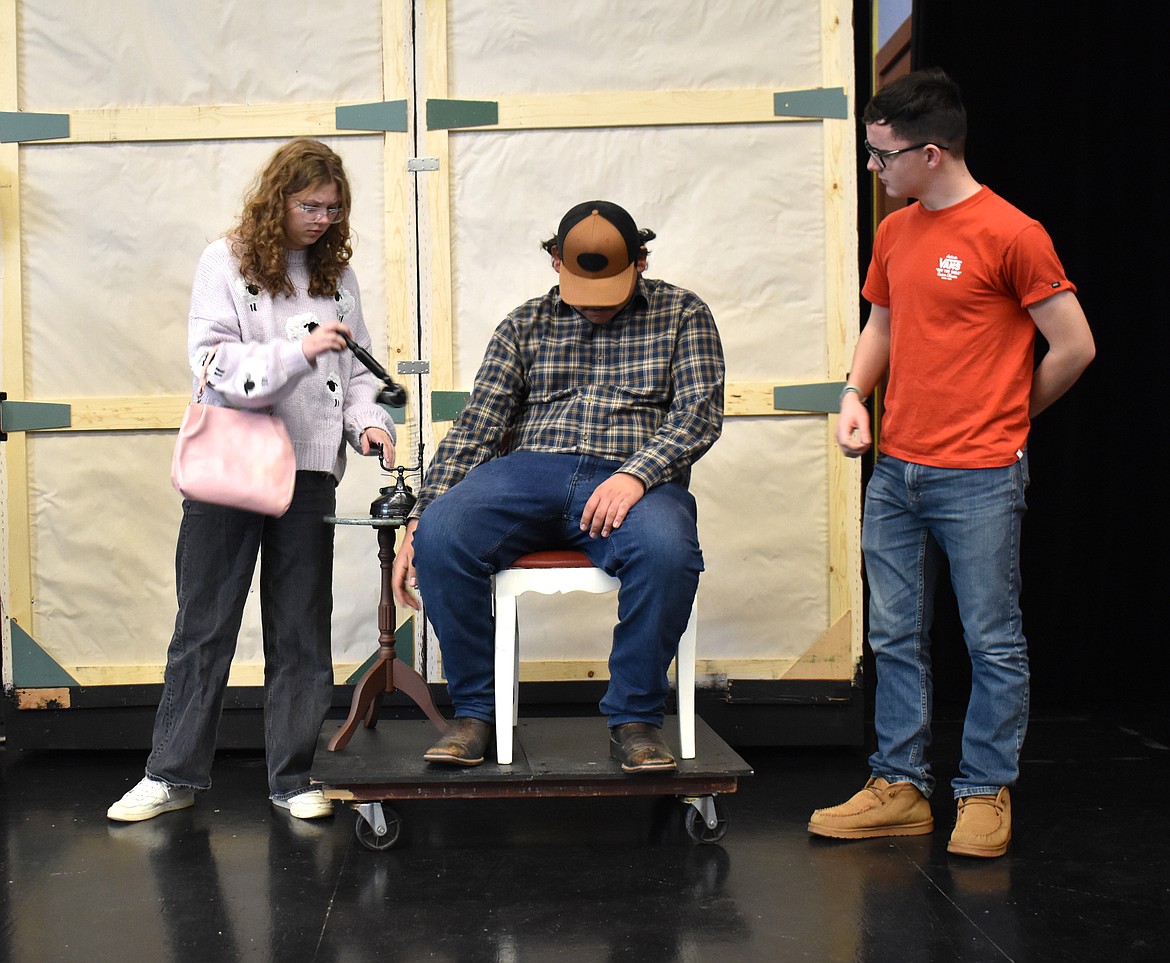 Mrs. Peacock (Karli Long), left, and Wadsworth (Sawyer Roylance), right, discover an unexpected cop unexpectedly deceased in a rehearsal of the Othello High School production of “Clue.”