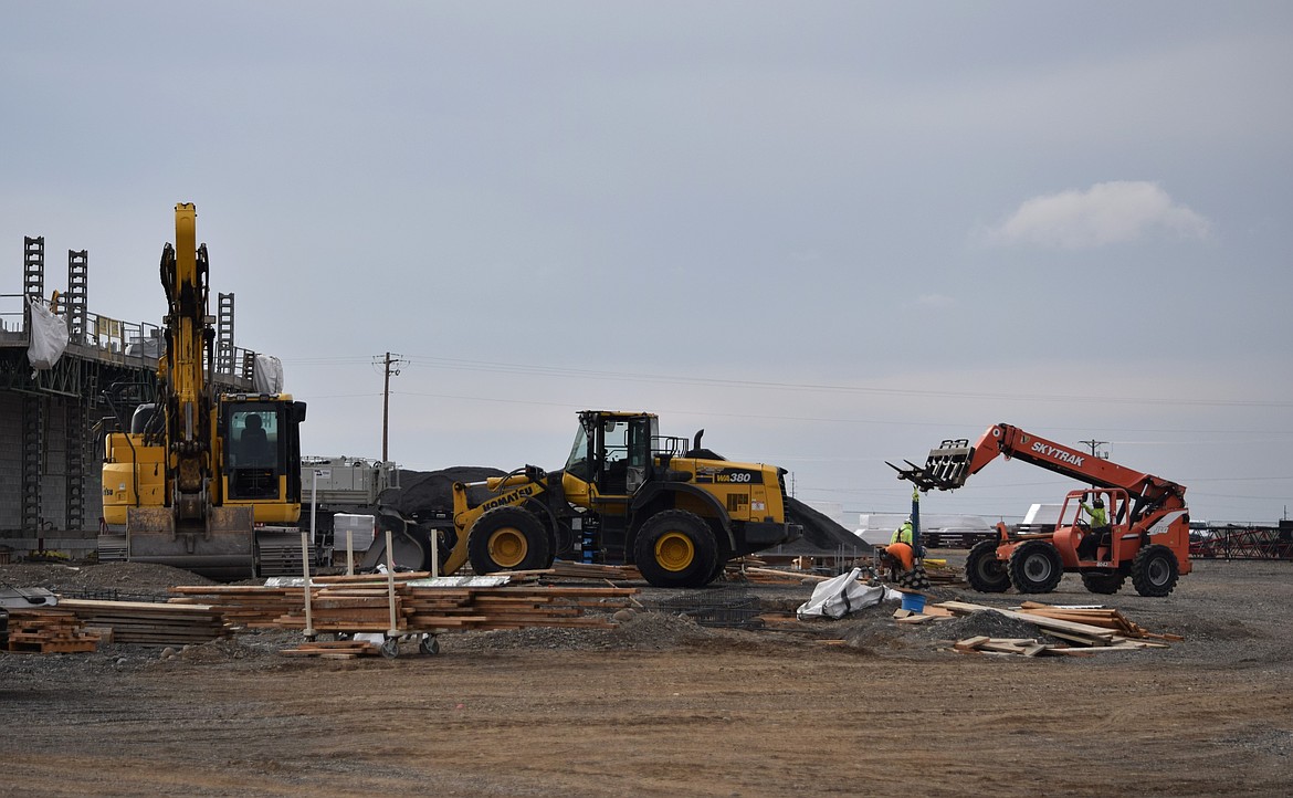 Workers use a variety of heavy equipment to move the construction of the new Grant County justice center along. The structure is made of steel, cement, plastic and other materials.