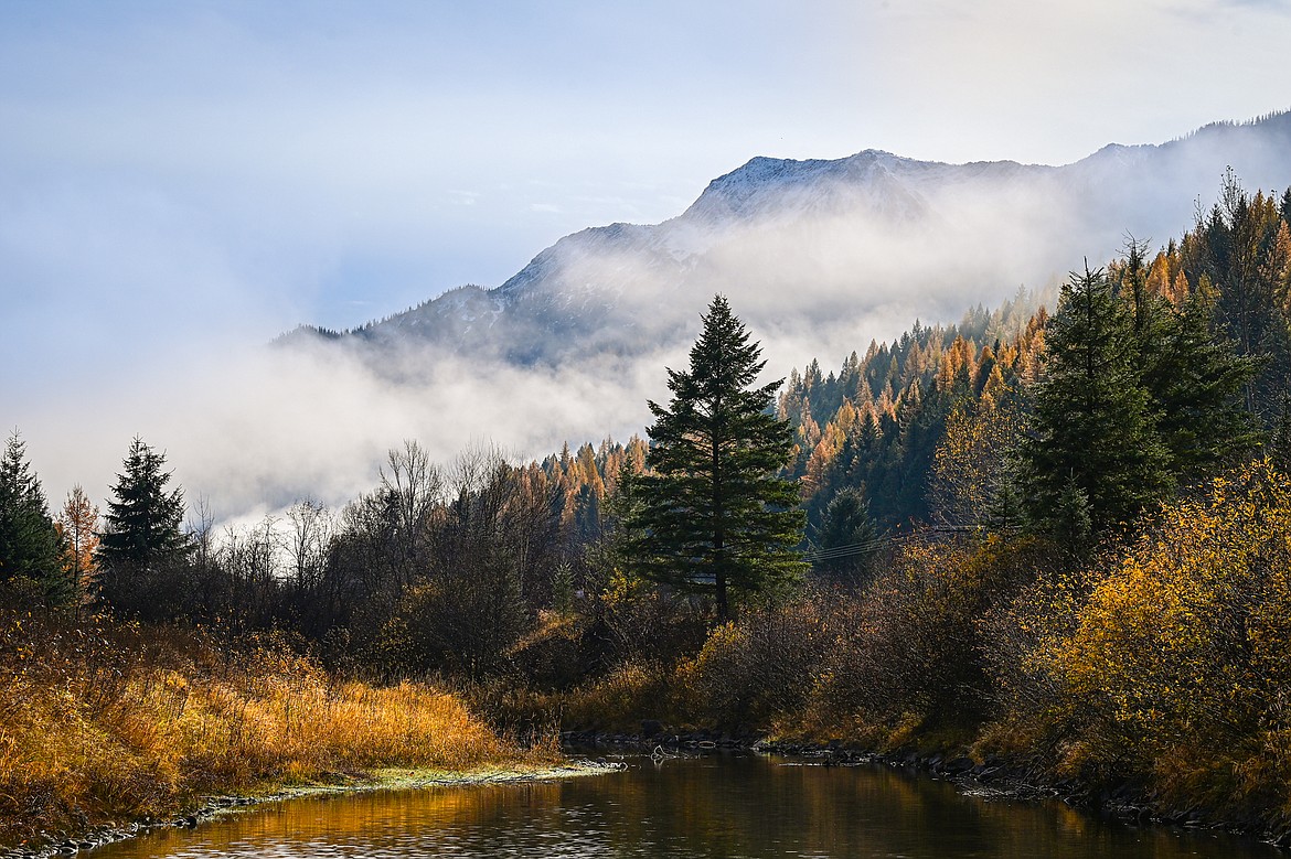 Fall colors and low clouds between Deerlick Creek and the shoulder of Mount Penrose along U.S. Highway 2 on Wednesday, Oct. 23. (Casey Kreider/Daily Inter Lake)