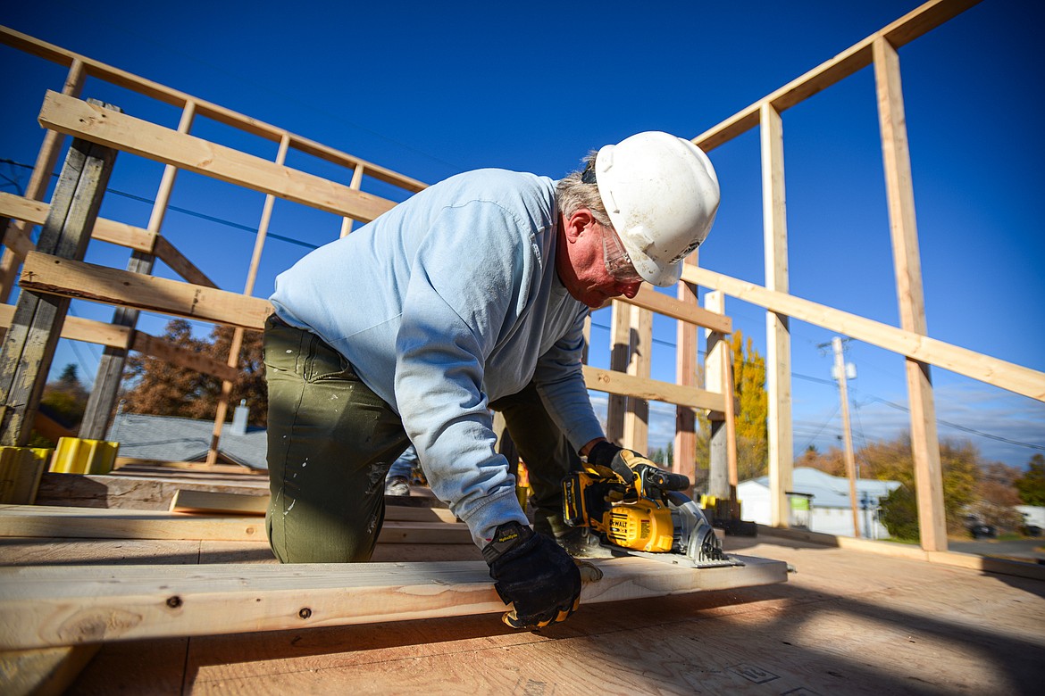 Volunteer Bill Rubly cuts boards for the second-floor wall frame of a duplex-style townhouse being built by Habitat for Humanity of Flathead Valley and Northwest Community Land Trust in Kalispell on Wednesday, Oct. 30. (Casey Kreider/Daily Inter Lake)