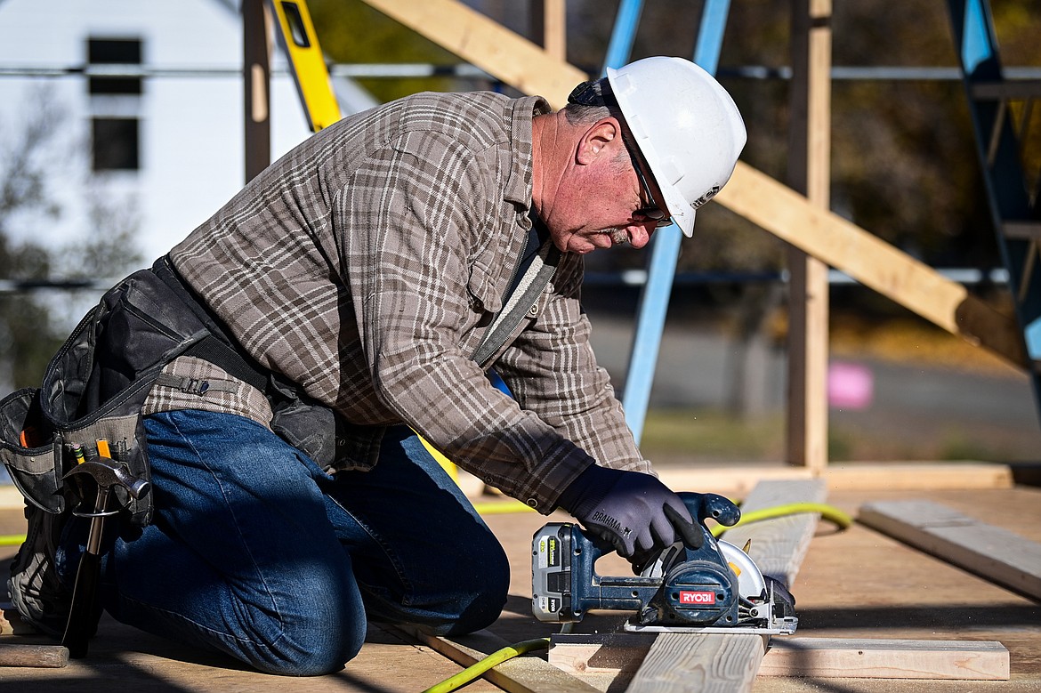 Volunteer Larry Schlotfeldt cuts boards for the second-floor wall frame of a duplex-style townhouse being built by Habitat for Humanity of Flathead Valley and Northwest Community Land Trust in Kalispell on Wednesday, Oct. 30. (Casey Kreider/Daily Inter Lake)