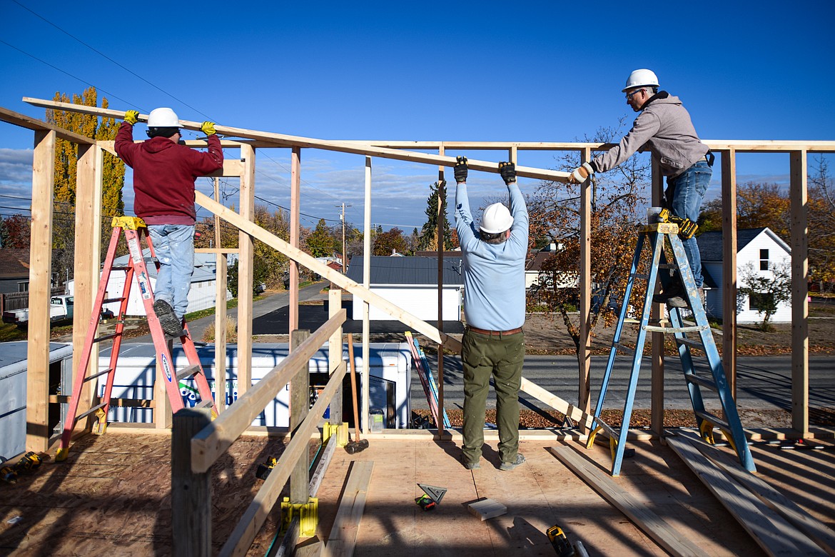 Volunteers Jim Poplin, Bill Rubly and Brian Putnam work on the second-floor wall frame of a duplex-style townhouse being built by Habitat for Humanity of Flathead Valley and Northwest Community Land Trust in Kalispell on Wednesday, Oct. 30. (Casey Kreider/Daily Inter Lake)