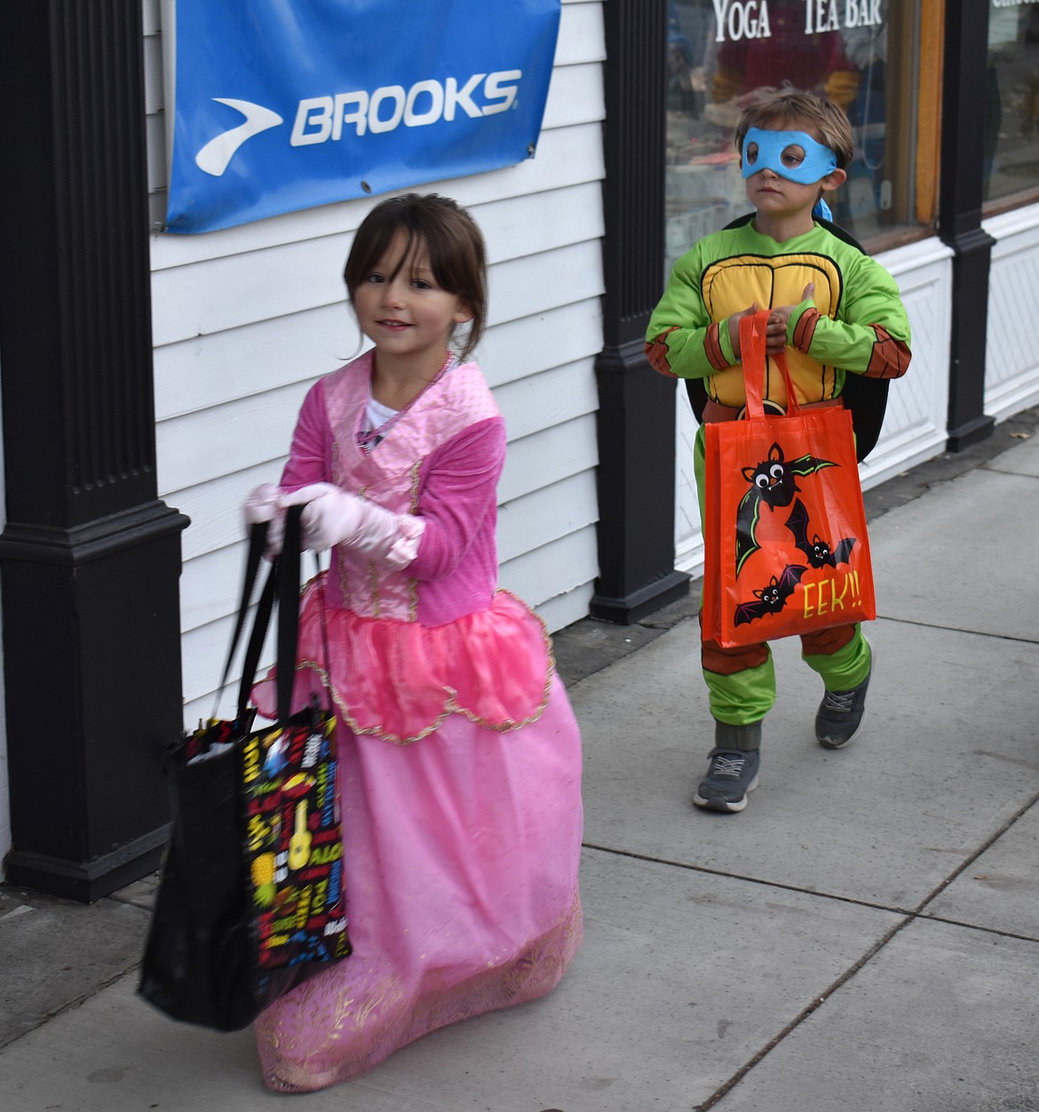 Aurora Rang, 7, left, and Wyatt Motzkus, 7, head down Basin Street Northwest in search of candy at Ephrata’s downtown trick-or-treat Thursday.