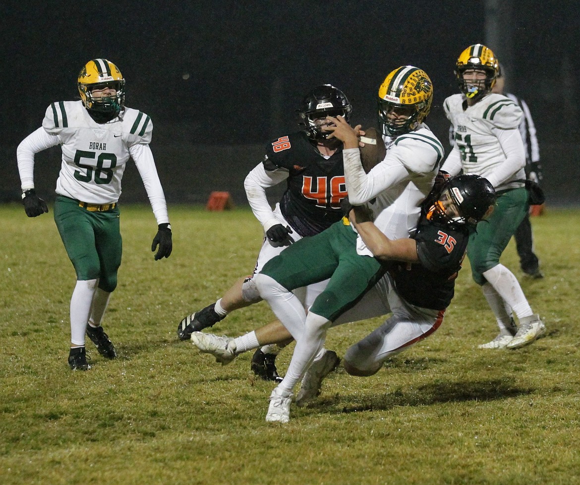 MARK NELKE/Press
Post Falls junior Marcus Sanchez sacks Borah quarterback Dylan Luekenga late in the first half, as Trojan senior Christopher Click (48) looks on, during a state 6A football first-round playoff game Friday night at Trojan Stadium.