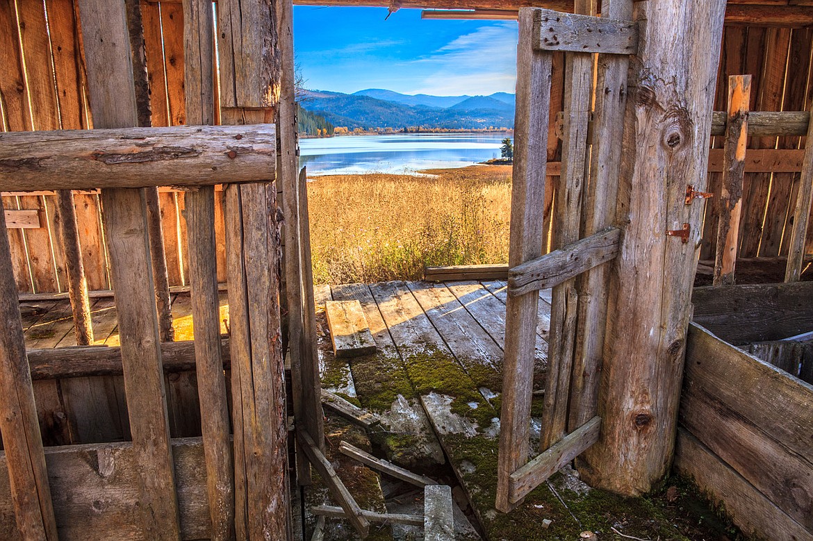 Killarney Lake and the surrounding mountains are framed through the doorway of an old doorway on a recent sunny day.