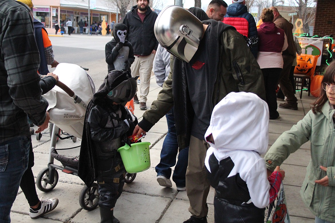 A Mandalorian hands out candy to Batman on Halloween in Quincy.